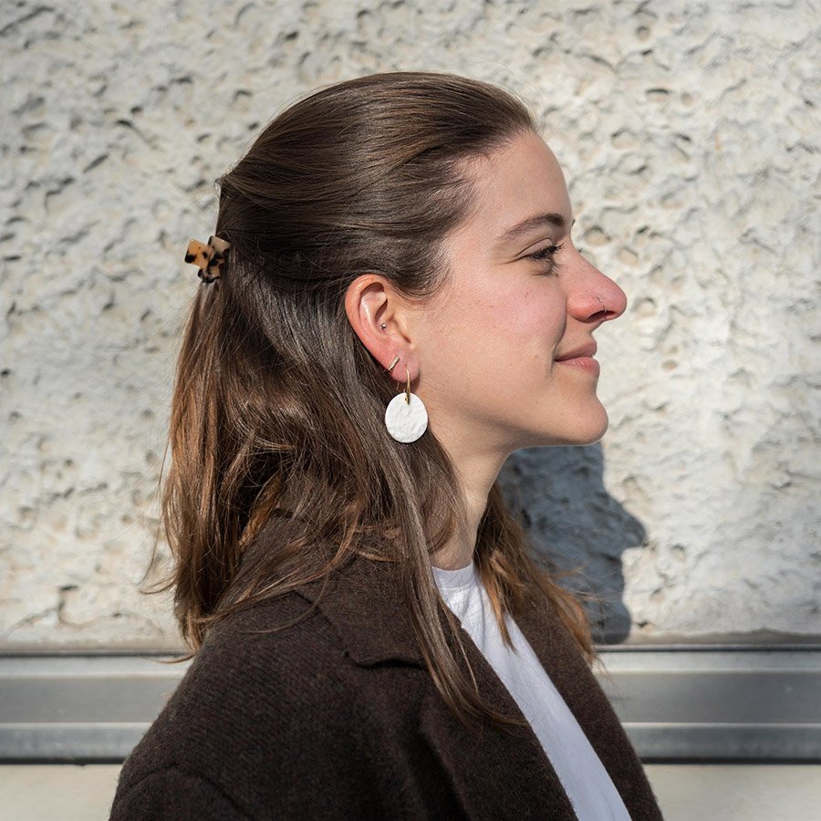 Minimalist large white porcelain disc earrings with gold-plated hooks on a white background